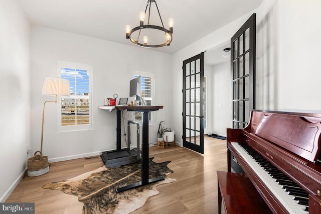 interior space featuring light wood-type flooring, a chandelier, and french doors