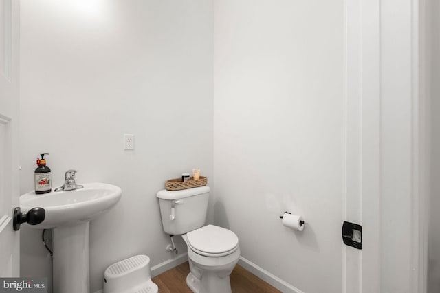 bathroom featuring toilet and wood-type flooring