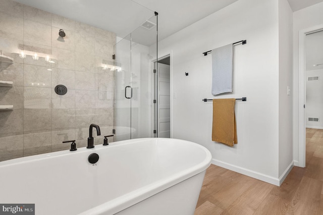 bathroom featuring hardwood / wood-style floors and separate shower and tub