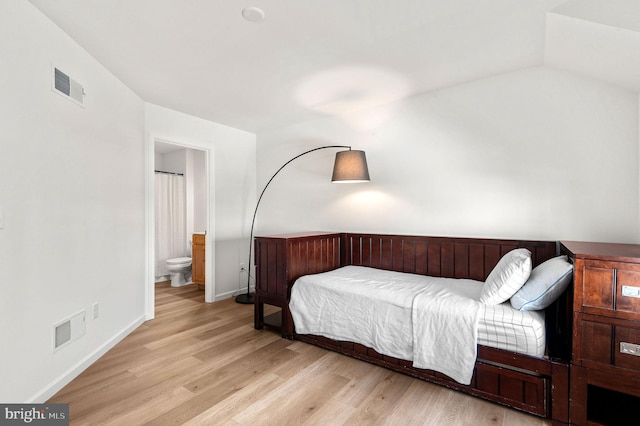 bedroom with light hardwood / wood-style floors and connected bathroom