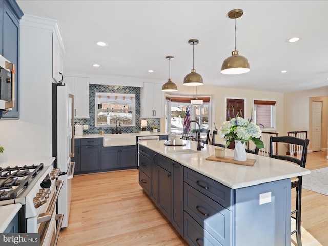 kitchen with white cabinetry, a center island, sink, and pendant lighting