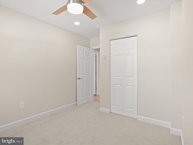 unfurnished bedroom with light carpet, a closet, and ceiling fan