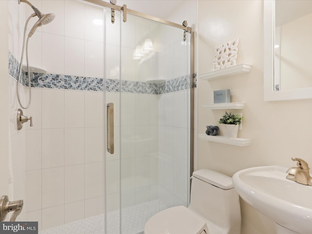 bathroom with sink, an enclosed shower, and toilet