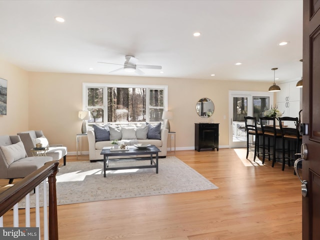 living room with a wealth of natural light, ceiling fan, and light hardwood / wood-style flooring