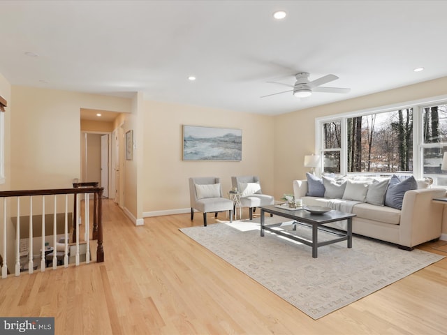 living room with ceiling fan and light hardwood / wood-style flooring