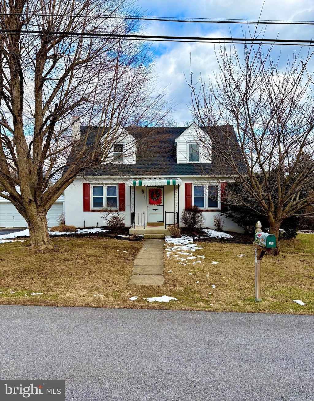 cape cod-style house featuring a front lawn