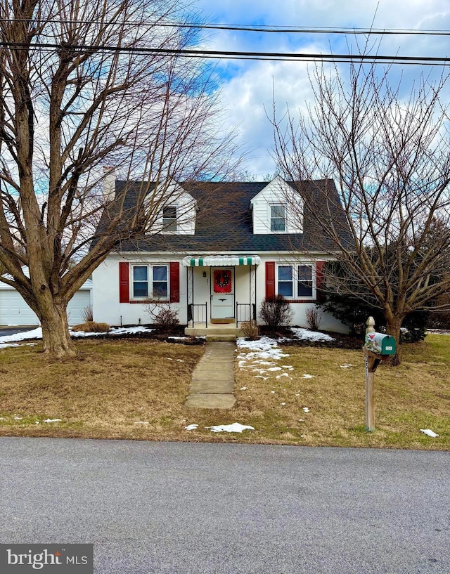 cape cod-style house featuring a front lawn