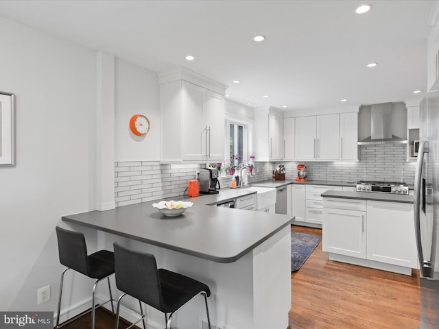 6230 21st St N, Arlington, VA 22205 - kitchen with wall chimney range hood, white cabinets, backsplash, and recessed lighting
