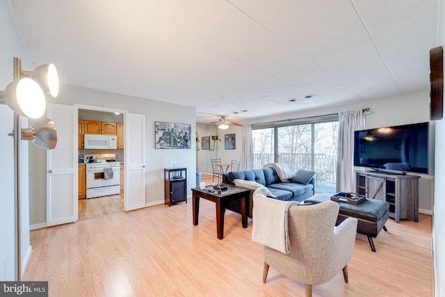 living room featuring light hardwood / wood-style flooring and ceiling fan