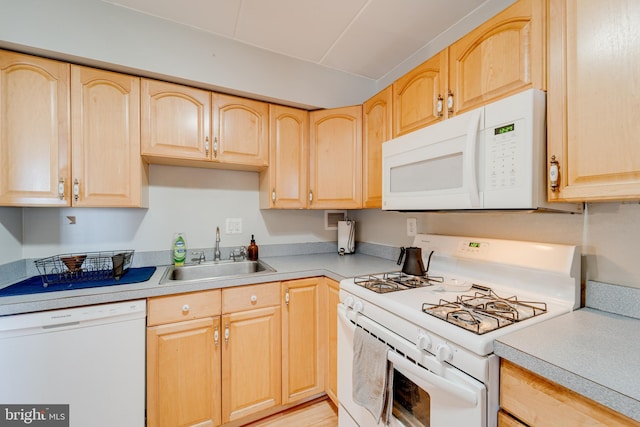 kitchen with sink, light brown cabinets, and white appliances