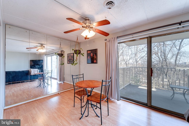 dining space with wood-type flooring and ceiling fan