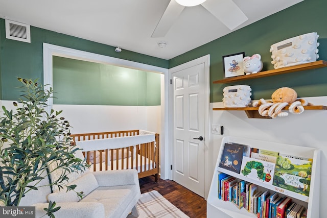 bedroom with dark wood-type flooring and a nursery area