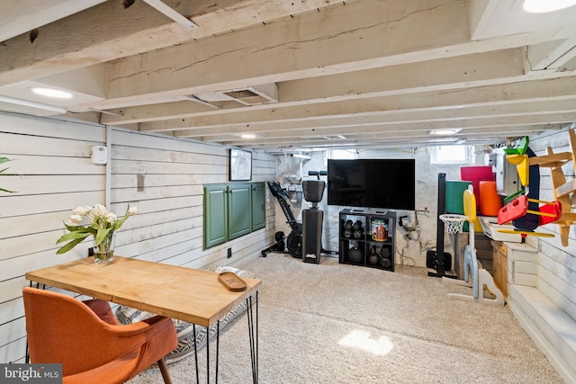 basement featuring carpet and wooden walls