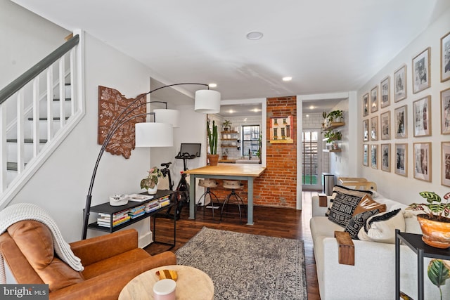 interior space with brick wall and dark hardwood / wood-style floors