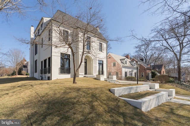 view of front of property featuring stucco siding, a residential view, brick siding, and a front yard