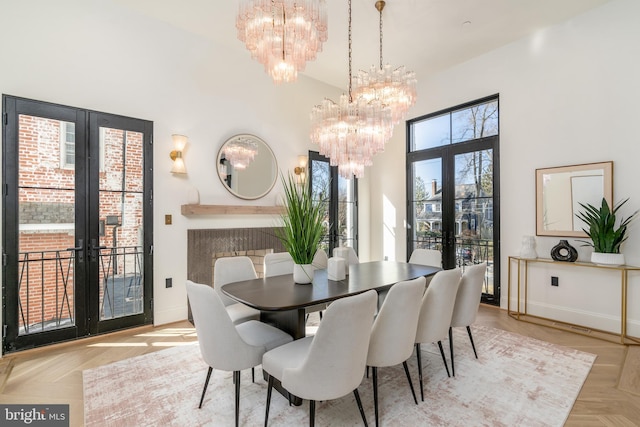 dining area featuring an inviting chandelier, a high ceiling, french doors, and baseboards