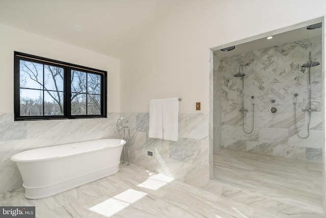 full bathroom with a marble finish shower, a freestanding bath, wainscoting, tile walls, and marble finish floor