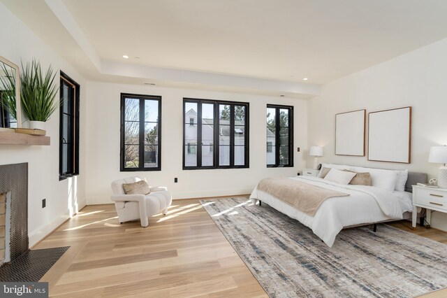 bedroom featuring recessed lighting, multiple windows, a fireplace with flush hearth, and baseboards