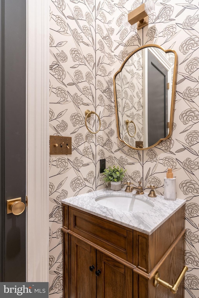 bathroom with wallpapered walls and vanity