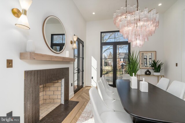 dining room with a notable chandelier, recessed lighting, french doors, parquet floors, and a tile fireplace