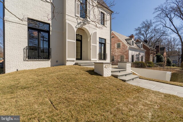 exterior space with brick siding and a lawn