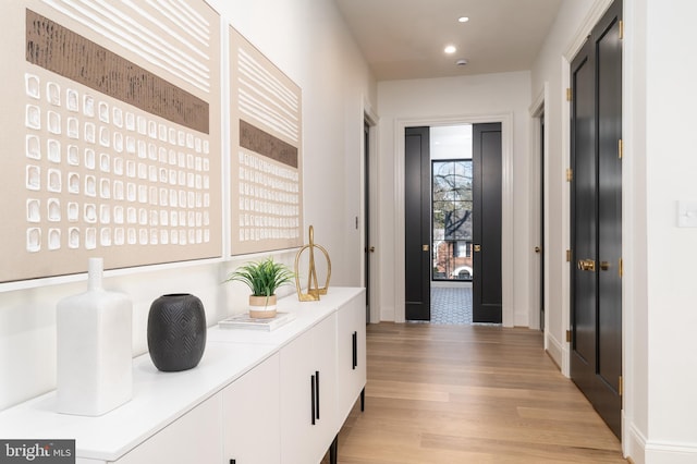 hall featuring recessed lighting, baseboards, and light wood-style floors