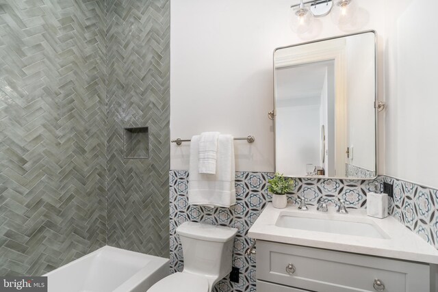 full bathroom with vanity, tile walls, and toilet