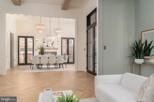 living room featuring baseboards, a chandelier, beam ceiling, french doors, and a high ceiling