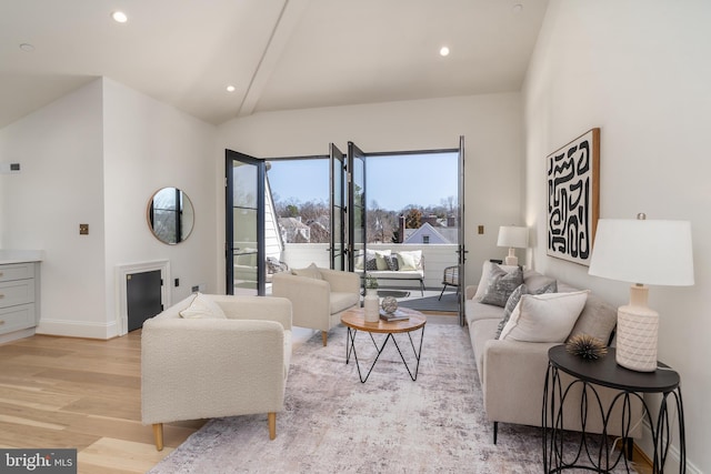 living area with recessed lighting, baseboards, lofted ceiling, and light wood-style floors