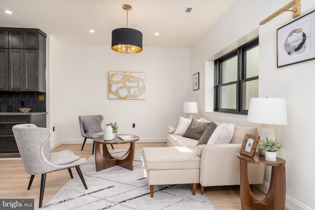 living room featuring recessed lighting, baseboards, and light wood-style floors