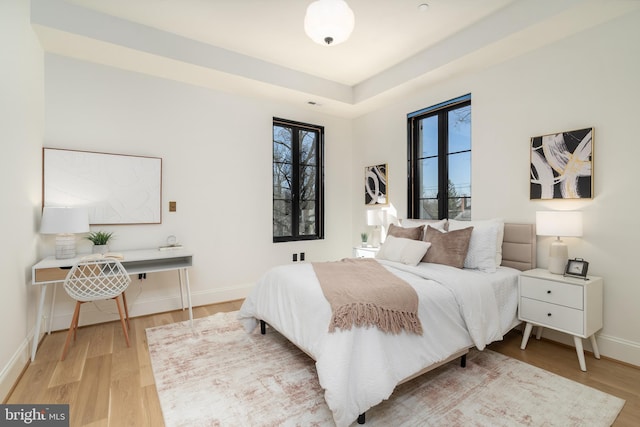 bedroom with visible vents, baseboards, and wood finished floors