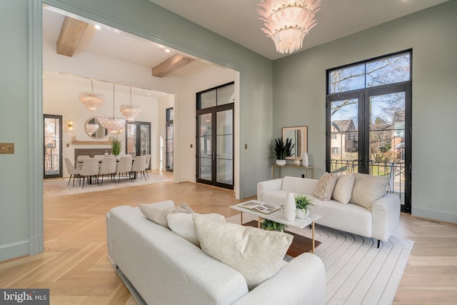 living area with beamed ceiling, a towering ceiling, french doors, baseboards, and a chandelier