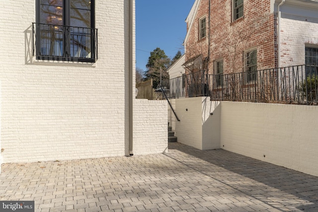 view of property exterior featuring a patio and fence