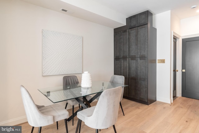 dining space featuring visible vents, light wood-type flooring, and baseboards