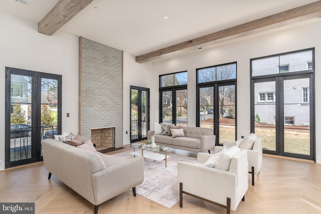 living room with beamed ceiling, french doors, and a towering ceiling