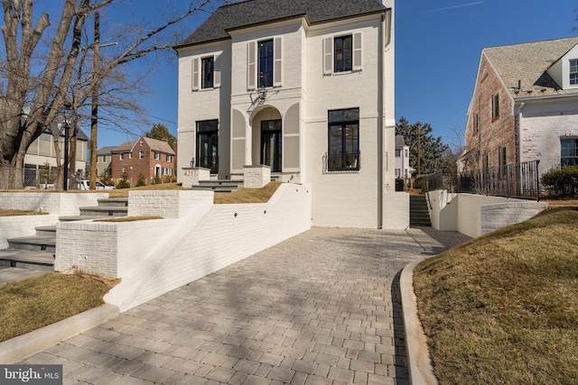 view of front of home with brick siding and fence