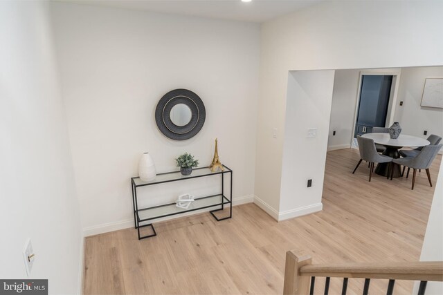 corridor with baseboards and wood finished floors