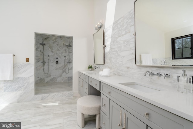 full bath with a sink, tile walls, double vanity, and a walk in shower