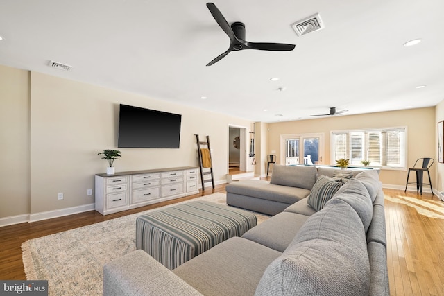 living room with ceiling fan and light hardwood / wood-style flooring