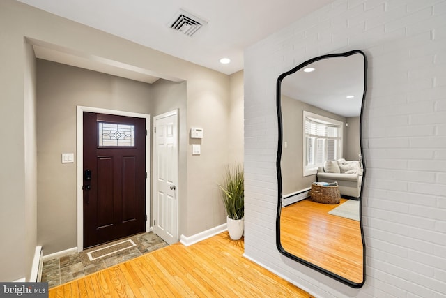 entryway featuring baseboard heating and wood-type flooring