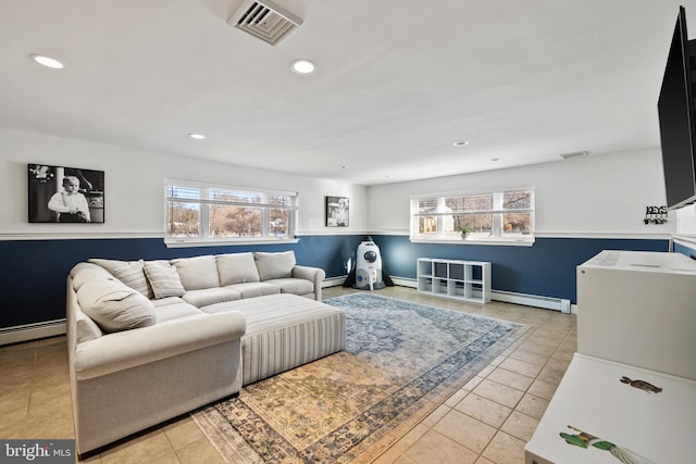 tiled living room with a baseboard radiator and plenty of natural light