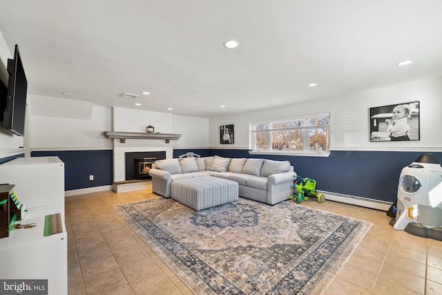 living room featuring light tile patterned flooring, a fireplace, and baseboard heating