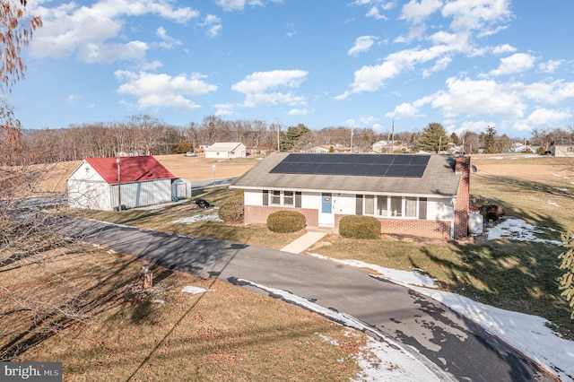 view of front of property featuring a front lawn and solar panels