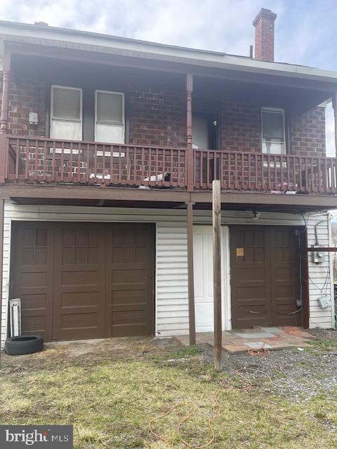 back of property featuring a garage and a yard