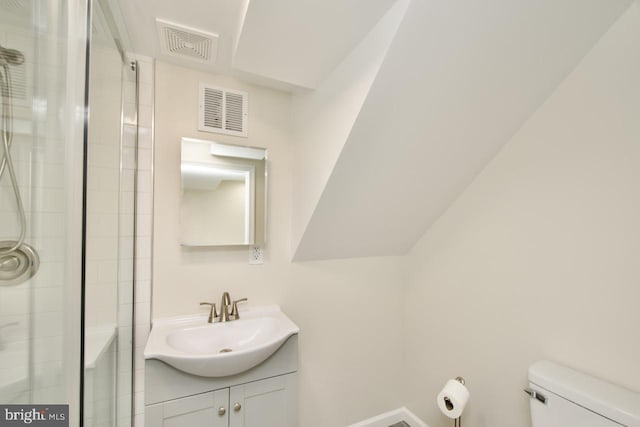 bathroom with vanity, a shower with door, and toilet