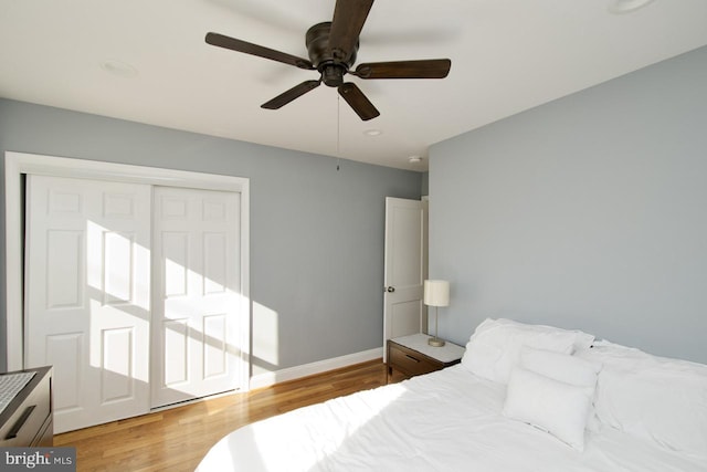 bedroom with ceiling fan, a closet, and light hardwood / wood-style flooring