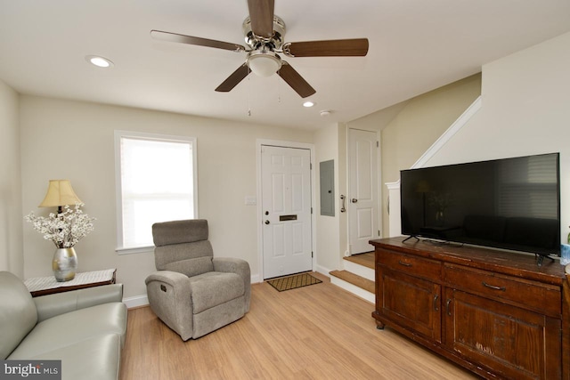 sitting room with light hardwood / wood-style flooring, electric panel, and ceiling fan