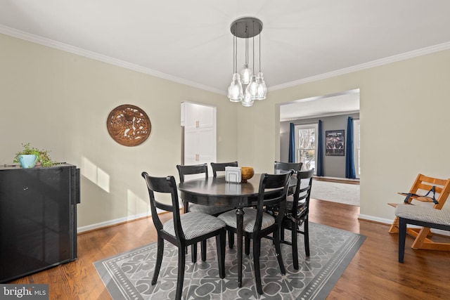 dining room with dark wood-type flooring and ornamental molding