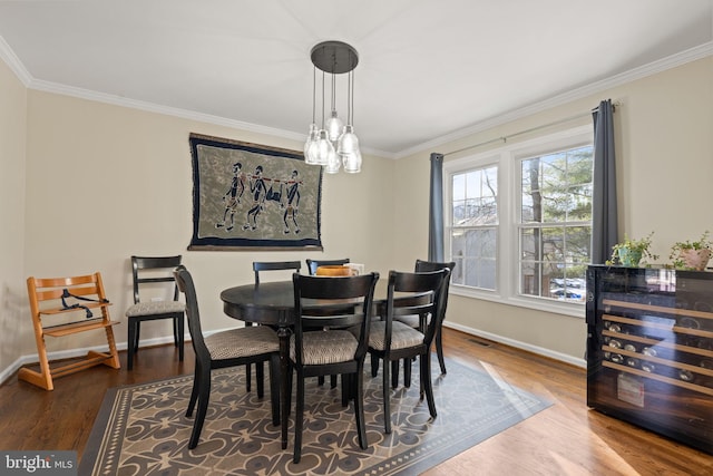 dining space with crown molding, beverage cooler, and dark hardwood / wood-style floors