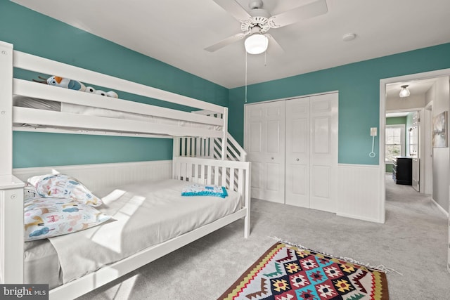 carpeted bedroom featuring ceiling fan and a closet